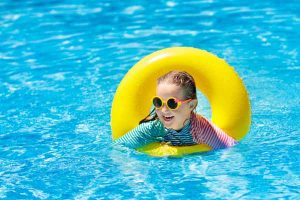 image of young girl in pool with sunglasses on